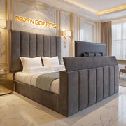 Modern bedroom with a large bed and decorative headboard, featuring 'BEDS N BOARDS' branding.
